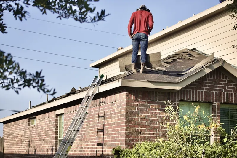 Professional roofer working on a residential roof in Newton Junction